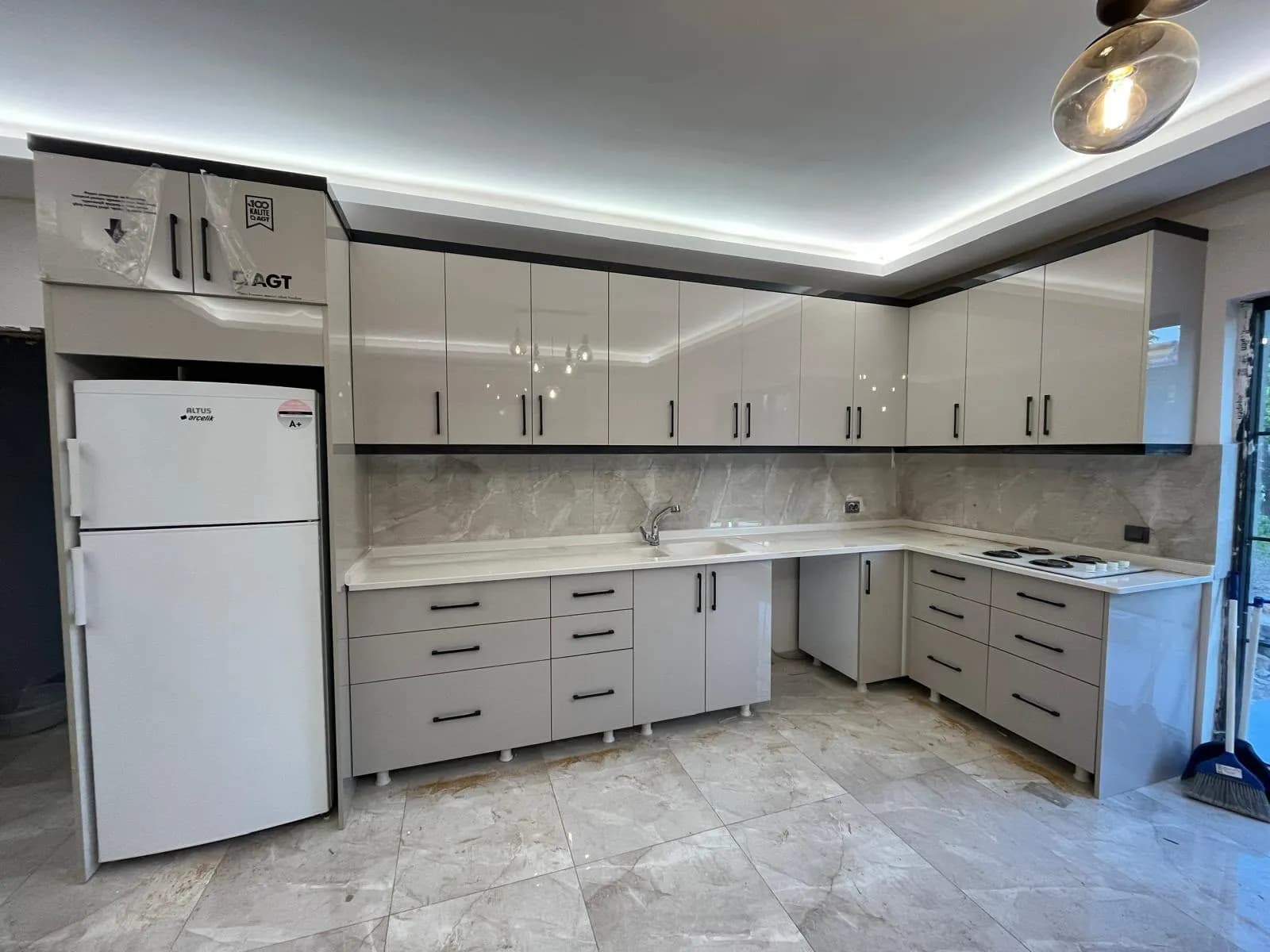 Tavanı aydınlatmalı, gri kapaklı L tipi mutfak dolabı montajı